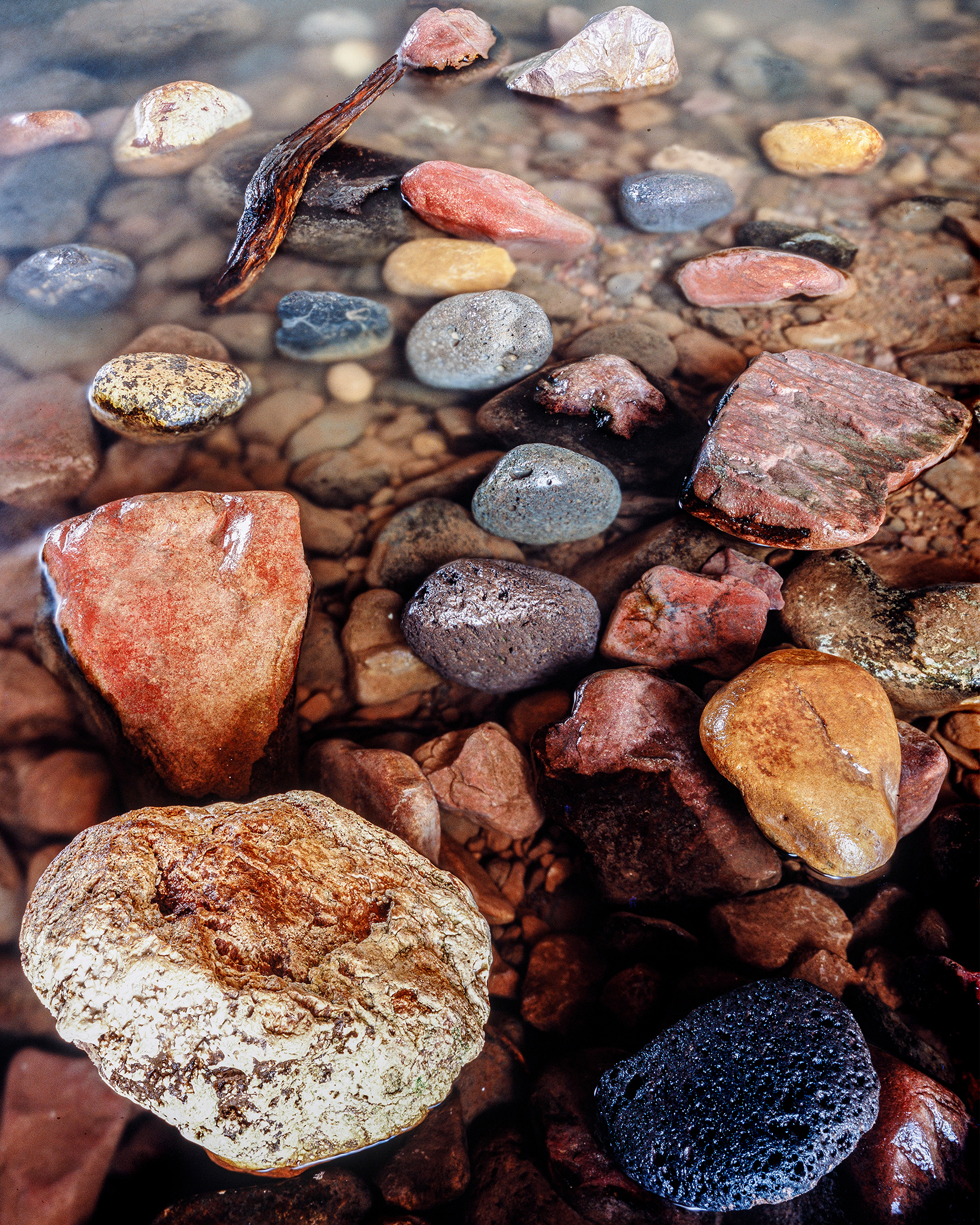 The plunge pool below Tonto Naturl Bridge is filled with cobbles of all sizes that show a good representation of the rocks surrounding the bridge.  The large white rock in the foreground is the Tonto Travertine, the dark black rock is the Buckhead Mesa Basalt, the other rocks include the Haigler Rhyolite (pink rocks) and the Pine Creek Conglomerate (bright red- orange).